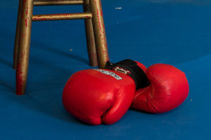 red boxing gloves next to a wooden stool