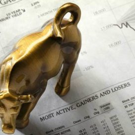 brass bull figurine on a stock market sheet