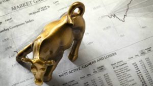 brass bull figurine on a stock market sheet