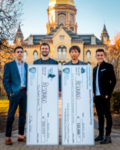 resonado team standing in front of the main building with large cardboard checks from the rice competition