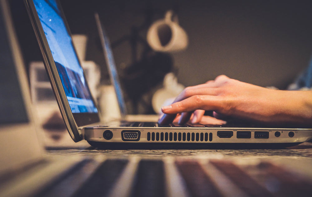 hands on a laptop computer keyboard in an office type setting