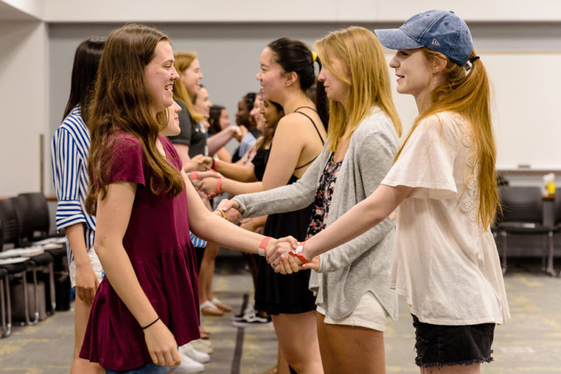 Young women learn how to shake hands
