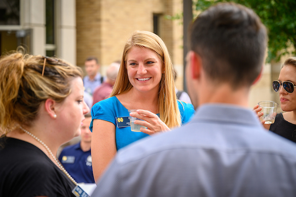 female MBA student smiling while deep in conversation at a networking event