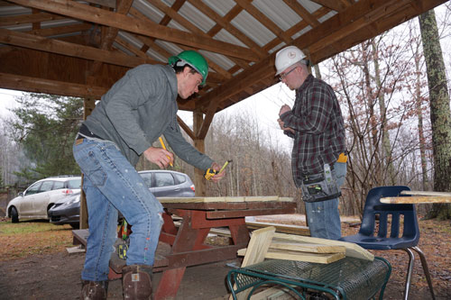 two men measuring cut timber