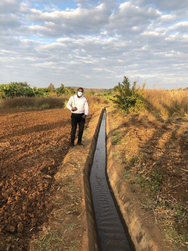 arthur stands next to a canal in malawi