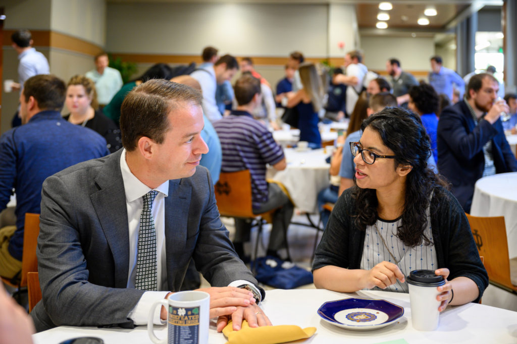 the dean speaking with an mba student at orientation breakfast