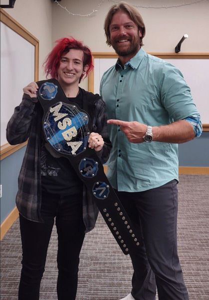 professor with student holding wwe-style belt