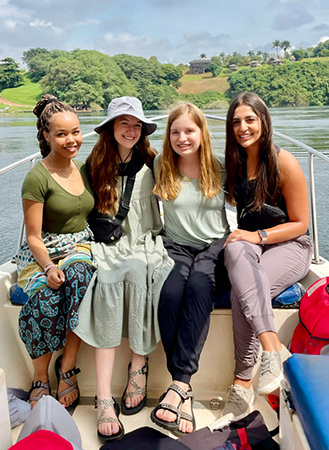 four students in a boat on Holy Cross Lake in Uganda