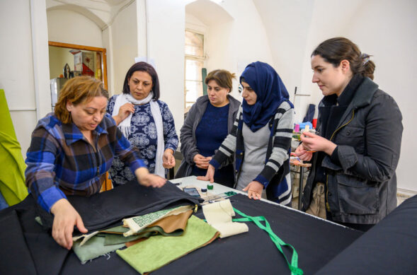 women over a fabric cutting station