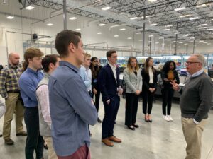 group photo of students listening to a presenter inside a warehouse