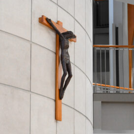 crucifix hanging on the outer wall of the stairwell in Mendoza.
