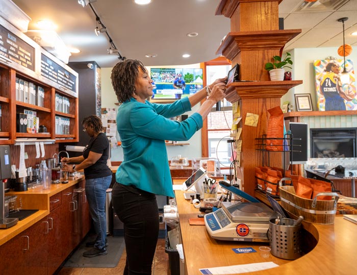 Tamika Catchings helps to prepare a tea order in her shop.