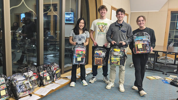 completed backpacks held up by students