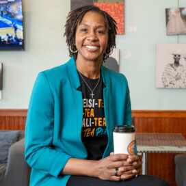 Tamika Catchings holding a cup in her tea shop.