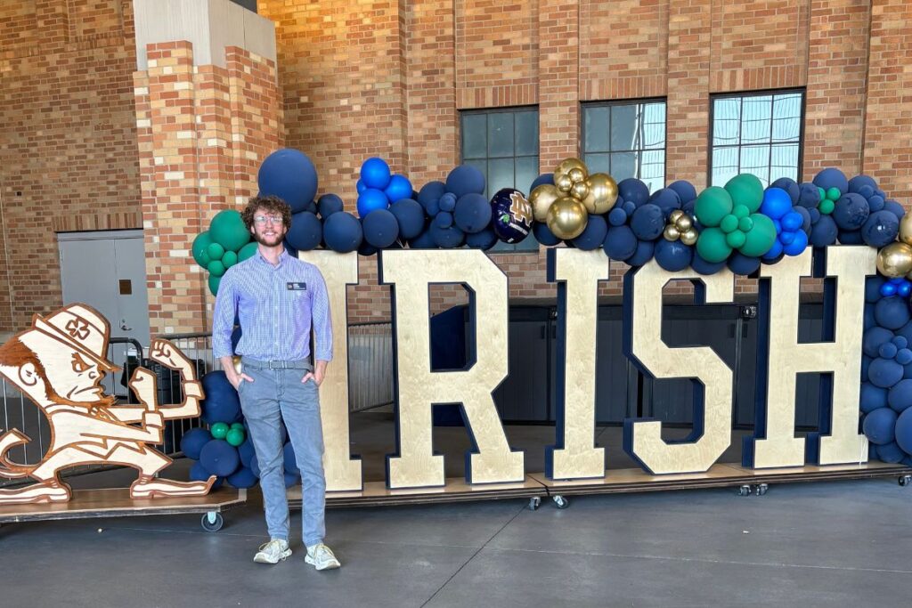 MNA candidate Louis Holbrook stands in front of "Irish" letters. 