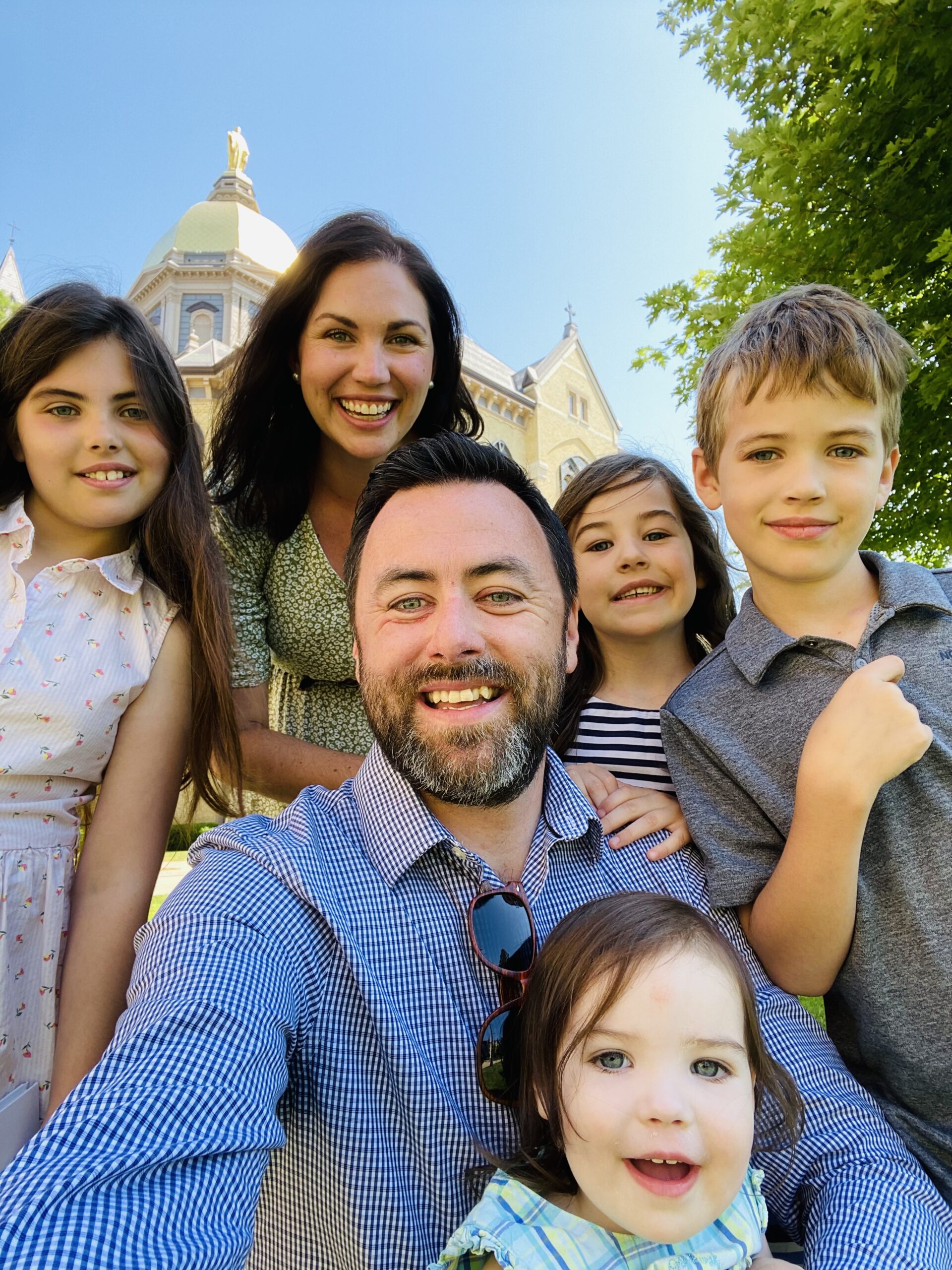 EMNA student Francis Doyle with his wife and children in front of Notre Dame's Main Building during a summer visit to campus. 