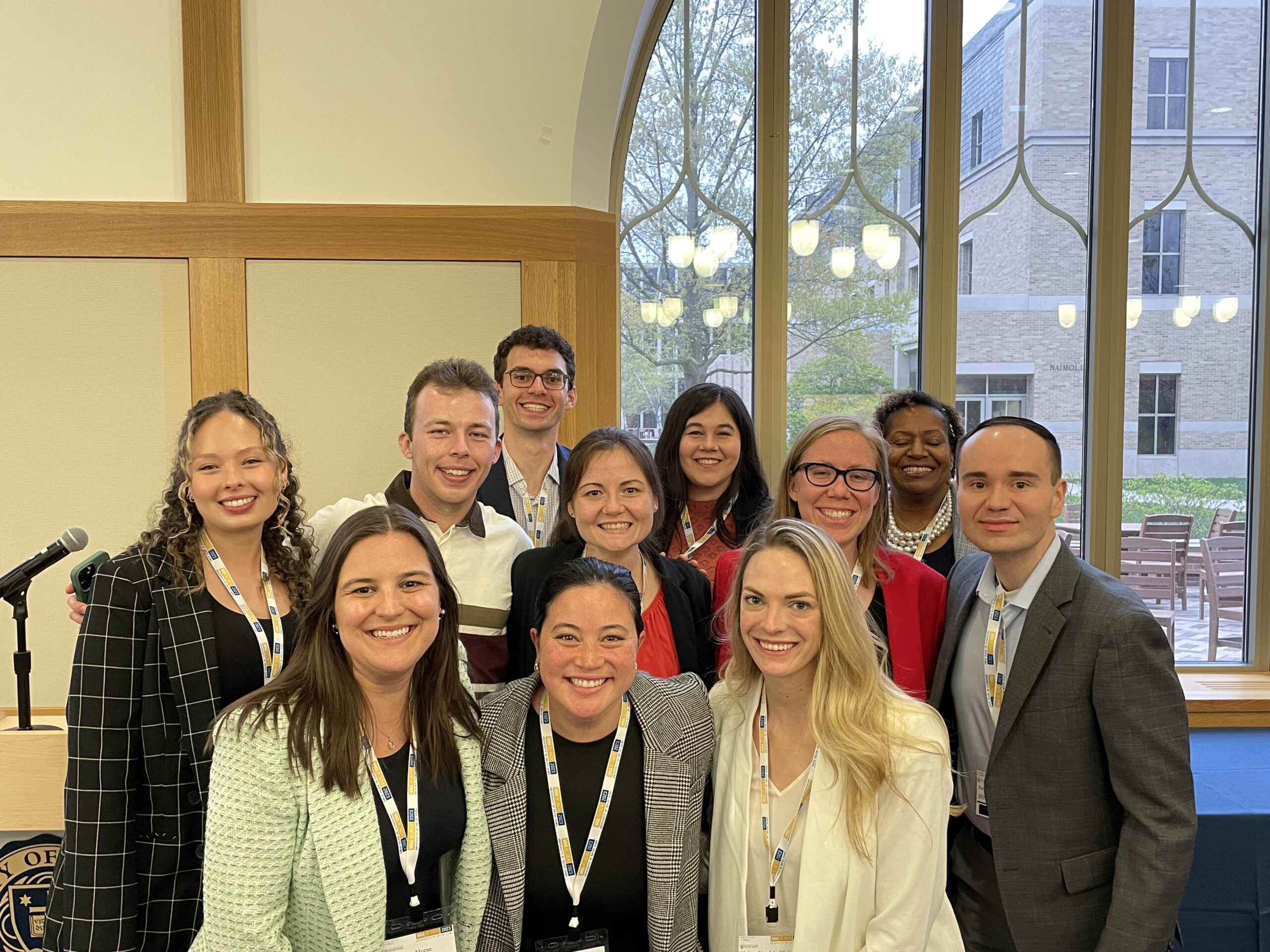 MNA alum Charlotte Harris with a group of her peers posting for a photo in front of a window on Notre Dame's campus.
