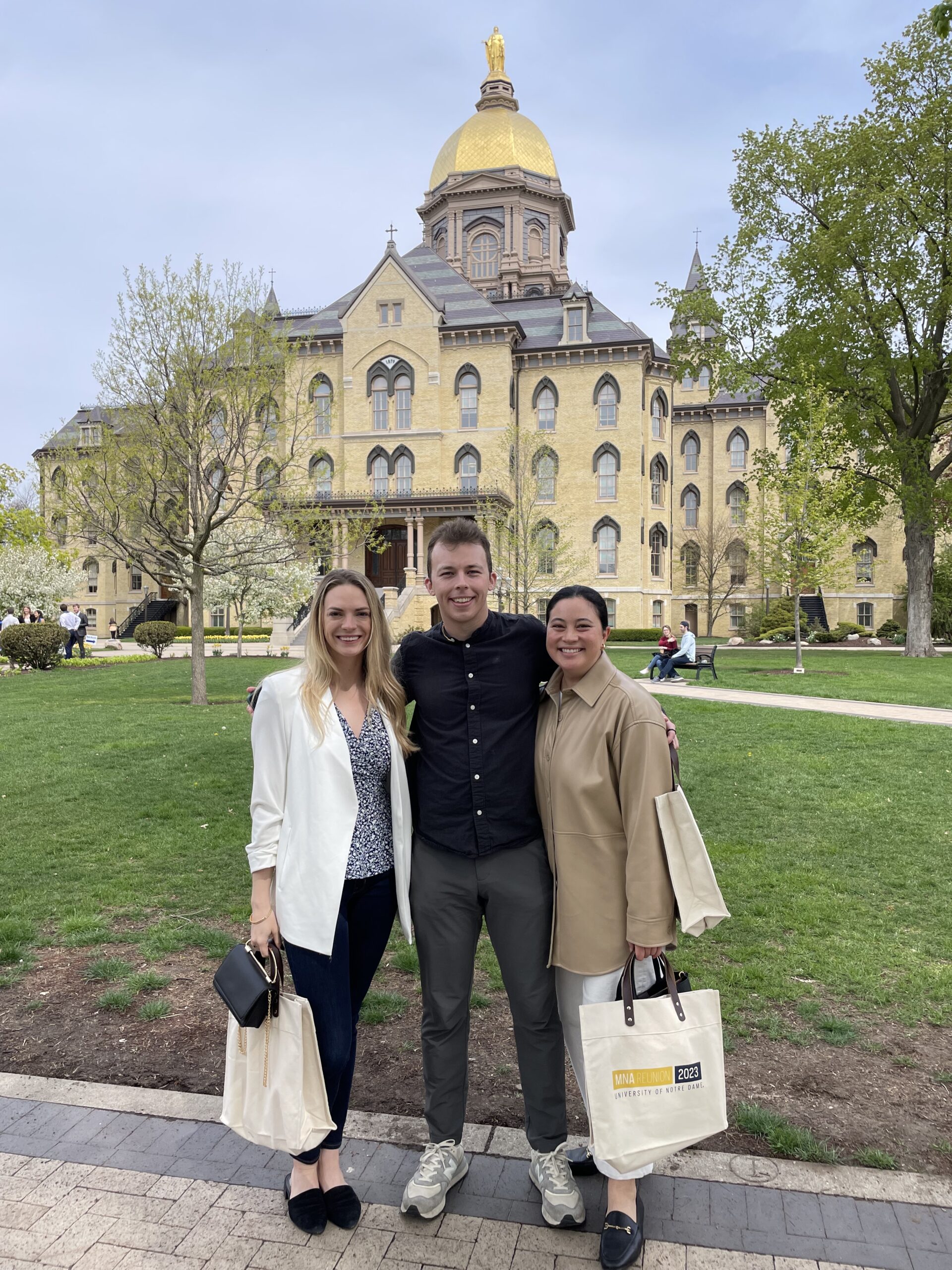MNA alum Charlotte Harris with friends posing in front of the Notre Dame main building.
