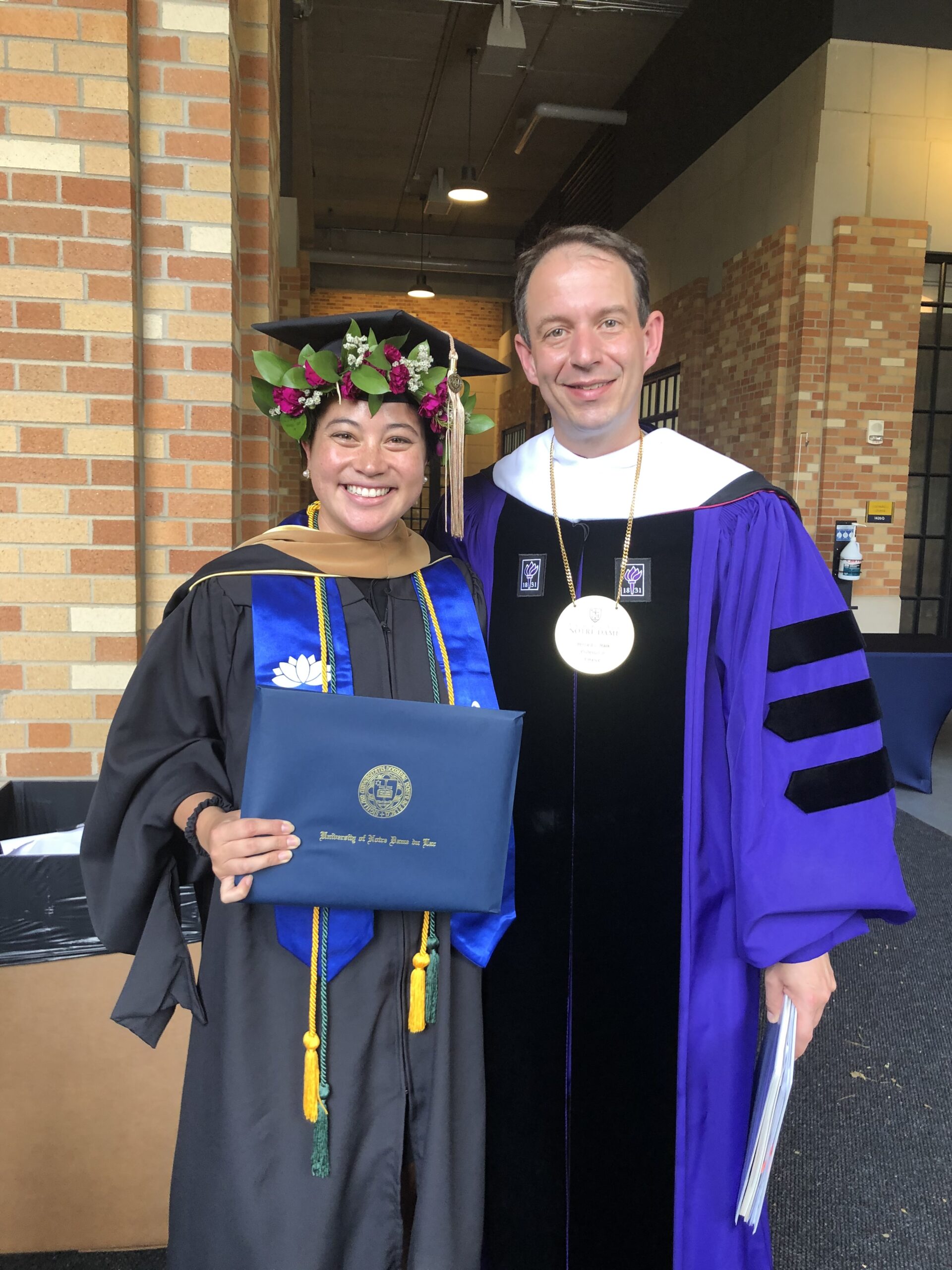 MNA alum Charlotte Harris at Commencement posing for a photo with Dean Martjin Cremers.