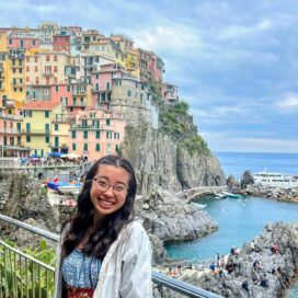 Katherine Huang poses for a picture with the Italian countryside behind her.