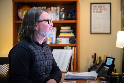 Kevin Hartman in profile, in his office looking at his computer.