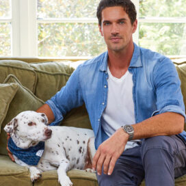 a dalmation sits next to Jordan Karcher on a sofa